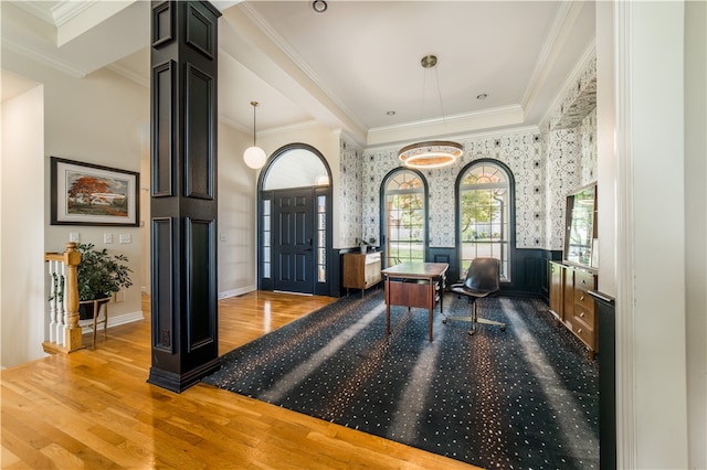 foyer entrance with wood finished floors, wallpapered walls, and crown molding