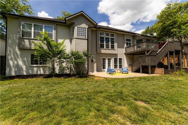 rear view of property with stairs, a patio, a wooden deck, and a lawn