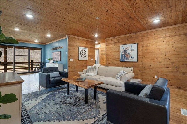 living room featuring wooden walls, wooden ceiling, wood finished floors, and visible vents