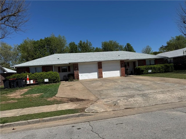 ranch-style house with concrete driveway, brick siding, a front lawn, and a garage