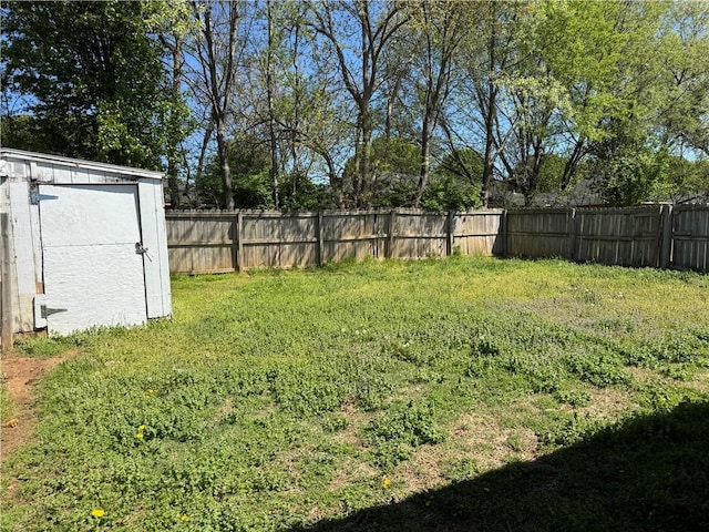 view of yard featuring a fenced backyard, an outbuilding, and a shed