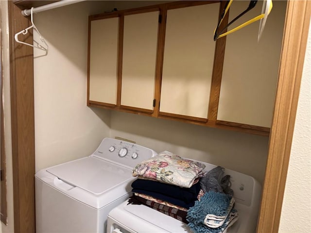 laundry room with separate washer and dryer and cabinet space