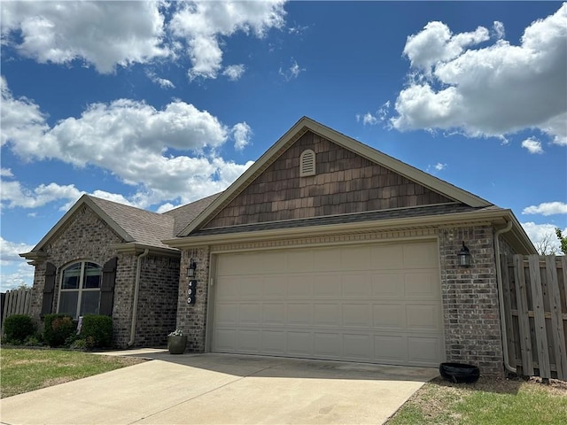 ranch-style house with concrete driveway, brick siding, a garage, and fence