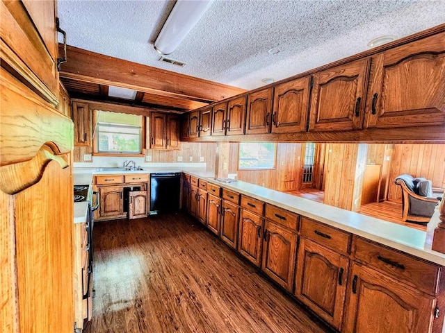 kitchen featuring brown cabinetry, a textured ceiling, and black appliances