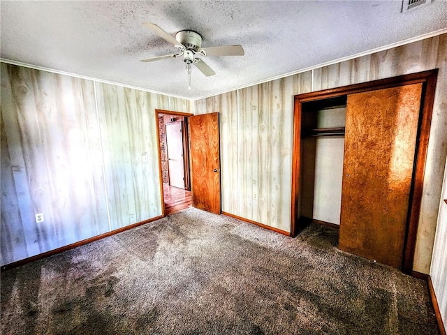 unfurnished bedroom featuring carpet floors, ornamental molding, a textured ceiling, and a closet