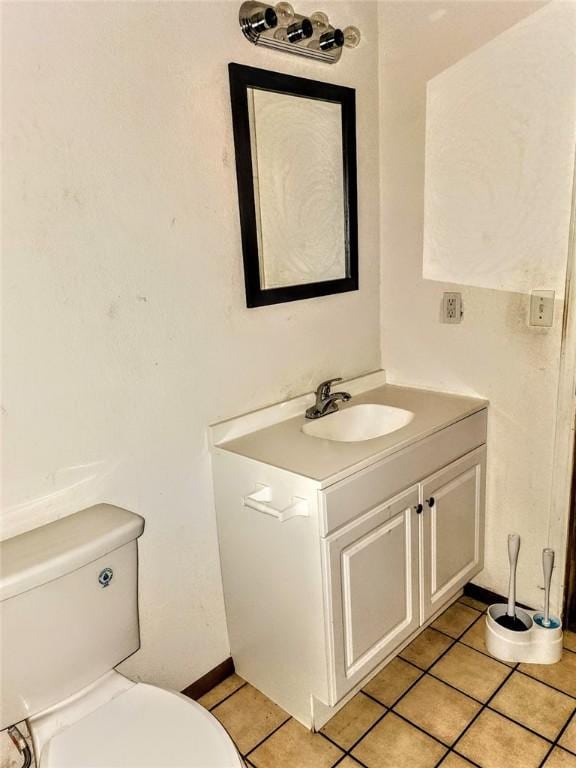 bathroom with toilet, tile patterned flooring, and vanity