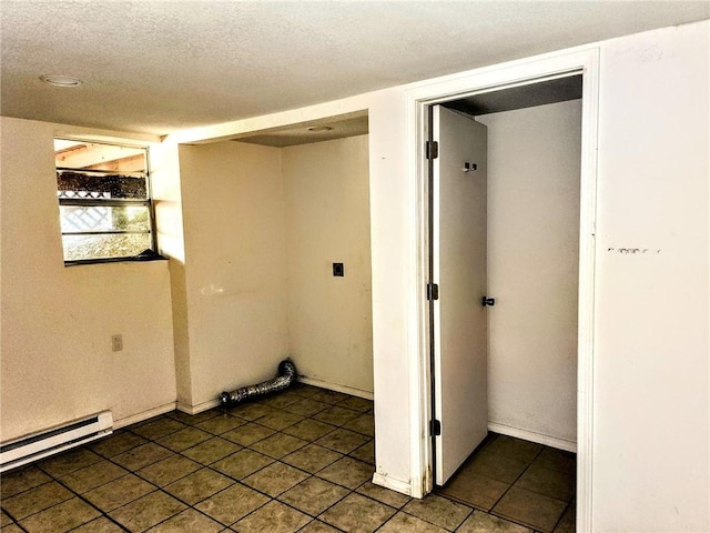 interior space with tile patterned flooring, a baseboard heating unit, and a textured ceiling