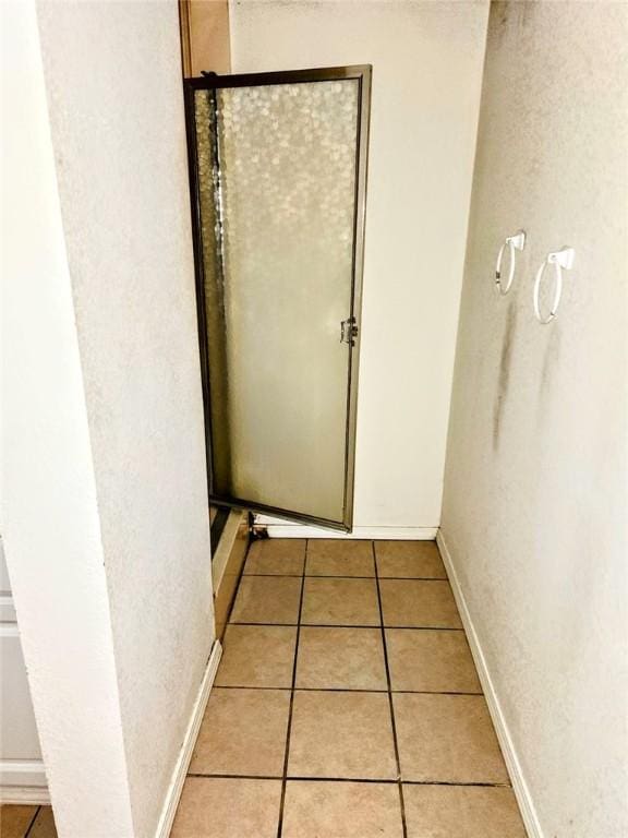 hall with baseboards and light tile patterned floors