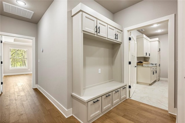 mudroom featuring baseboards, visible vents, and light wood-style flooring