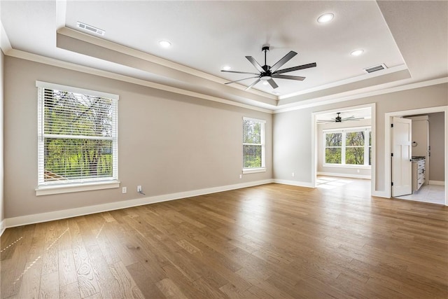unfurnished room with crown molding, a tray ceiling, visible vents, and ceiling fan