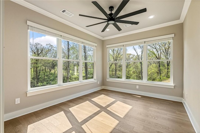empty room featuring visible vents, ornamental molding, baseboards, and ceiling fan