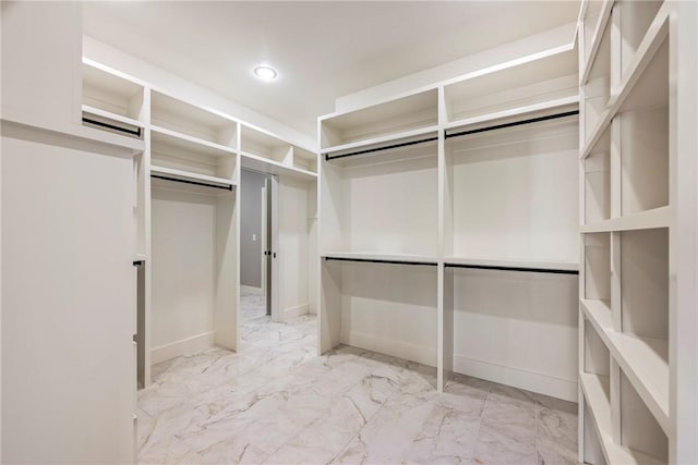 walk in closet featuring marble finish floor
