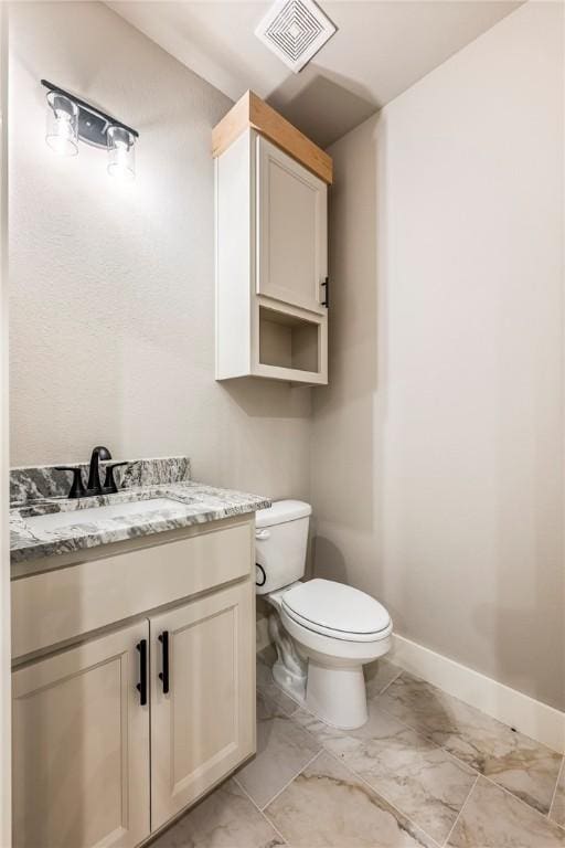 bathroom with visible vents, vanity, baseboards, toilet, and marble finish floor
