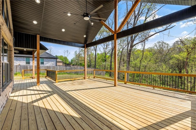 wooden deck with ceiling fan and a fenced backyard