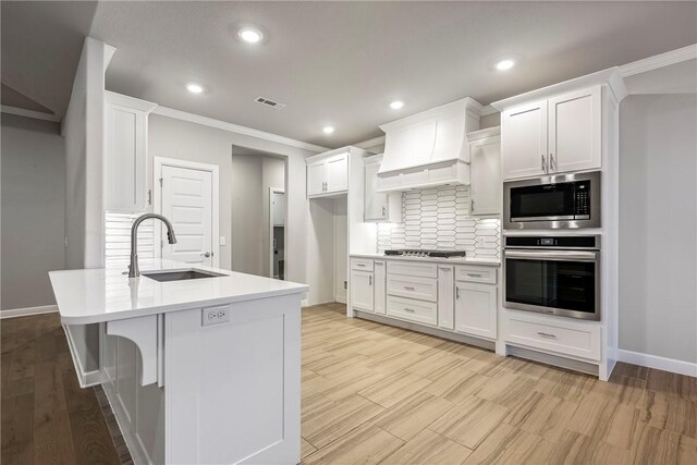 2109 Abbott Ln, Pea Ridge, AR 72751 - kitchen featuring stainless steel appliances, a sink, baseboards, crown molding, and backsplash