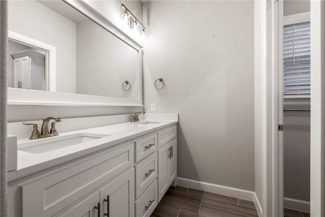 2109 Abbott Ln, Pea Ridge, AR 72751 - bathroom featuring baseboards, double vanity, and wood finished floors
