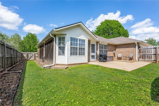 back of house featuring a lawn, a fenced backyard, a patio area, and brick siding