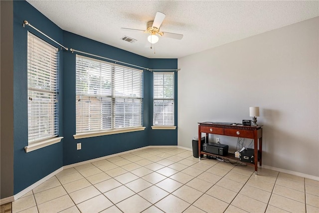 unfurnished room with a ceiling fan, a textured ceiling, visible vents, and light tile patterned floors