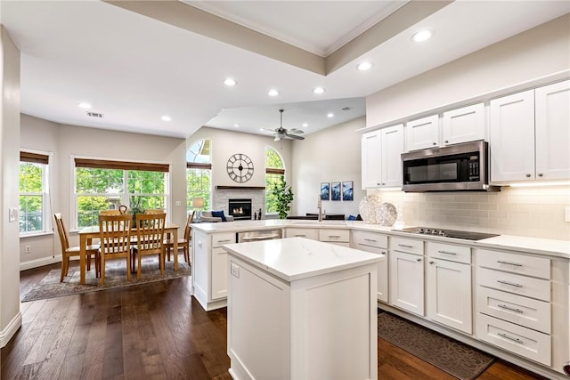 kitchen featuring a peninsula, light countertops, appliances with stainless steel finishes, ornamental molding, and recessed lighting