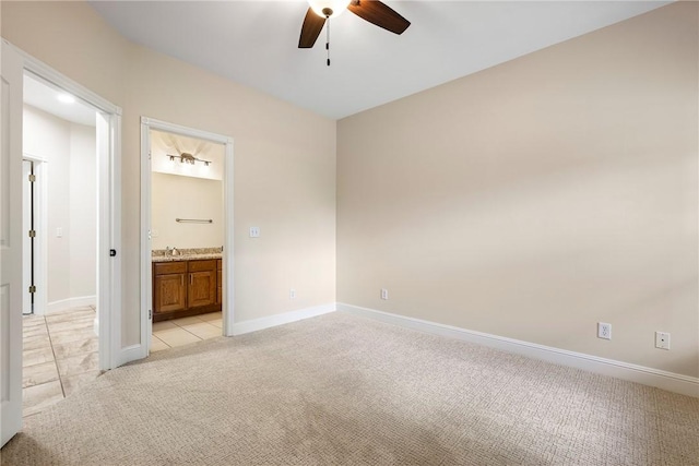unfurnished bedroom featuring light colored carpet, baseboards, and a sink