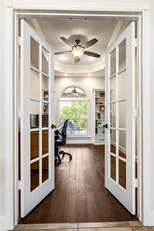 office with french doors, ornamental molding, dark wood finished floors, ceiling fan, and a raised ceiling