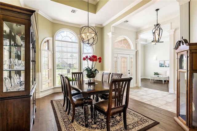 dining area with ornamental molding, visible vents, and dark wood-type flooring