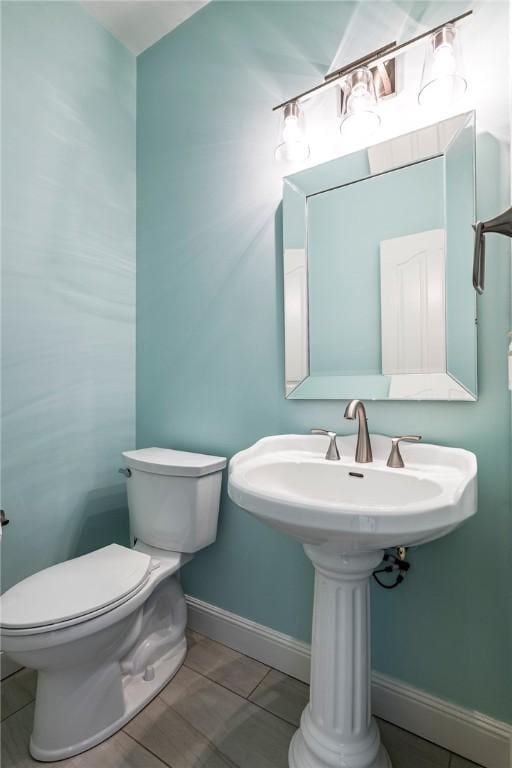 half bathroom with toilet and baseboards