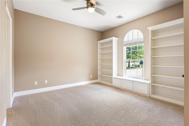 empty room with light carpet, baseboards, visible vents, and ceiling fan