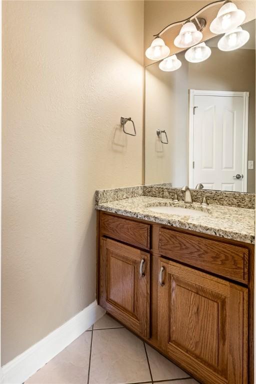 bathroom with baseboards, vanity, and tile patterned flooring