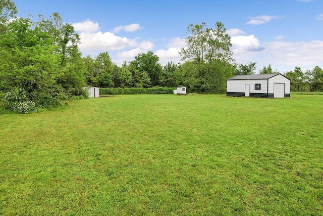 view of yard with an outdoor structure, a garage, and a shed