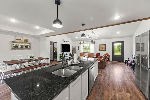 kitchen with a sink, lofted ceiling, dark wood-style flooring, and open floor plan