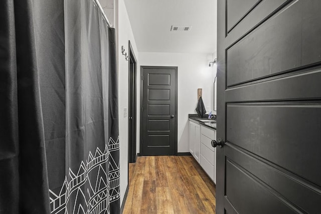 bathroom featuring a shower with curtain, visible vents, wood finished floors, and vanity