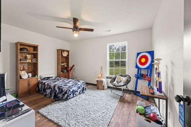 bedroom featuring ceiling fan, visible vents, and wood finished floors