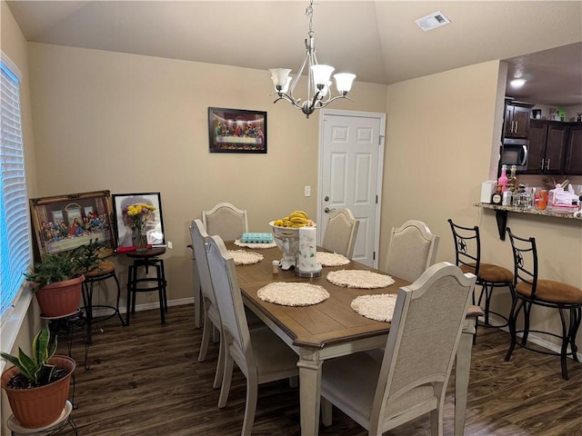 dining area with a notable chandelier, vaulted ceiling, dark wood finished floors, and visible vents