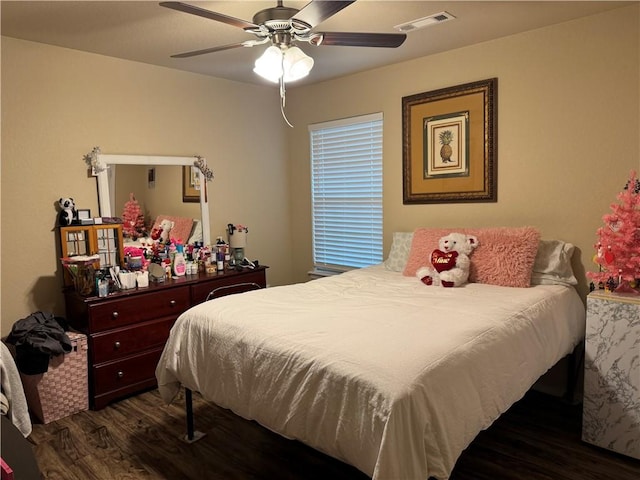 bedroom with a ceiling fan, wood finished floors, and visible vents