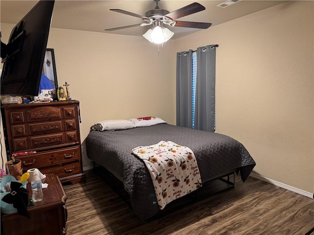 bedroom with a ceiling fan, baseboards, and dark wood-style floors