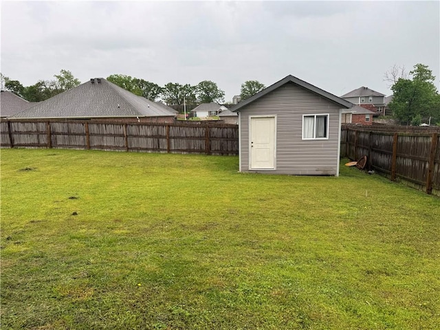 view of yard featuring a storage shed, an outbuilding, and a fenced backyard