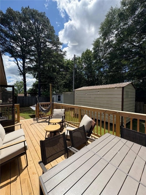 809 Walnut, Dardanelle, AR 72834 - wooden terrace with a storage unit, fence, an outbuilding, and outdoor dining space