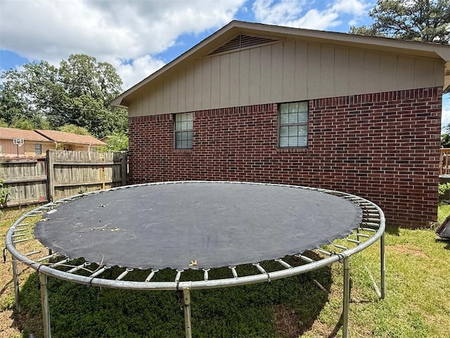 809 Walnut, Dardanelle, AR 72834 - view of home's exterior with fence, a trampoline, a lawn, and brick siding