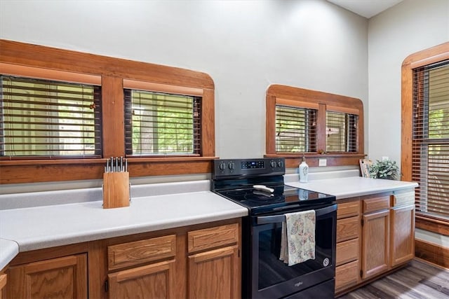 605 N Wright St, Siloam Springs, AR 72761 - kitchen with light countertops, brown cabinetry, black electric range oven, and wood finished floors