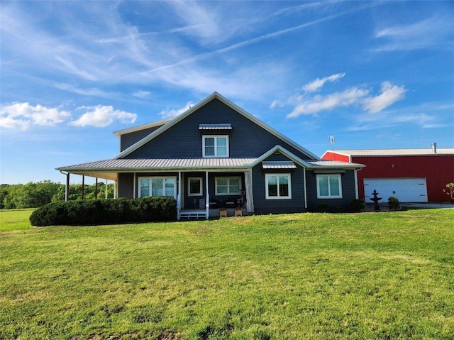farmhouse inspired home featuring metal roof, a front yard, and a garage