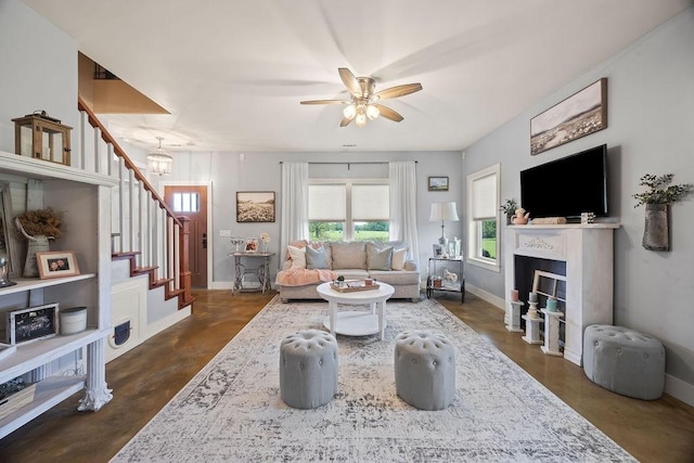 living area with baseboards, a ceiling fan, a healthy amount of sunlight, and stairway