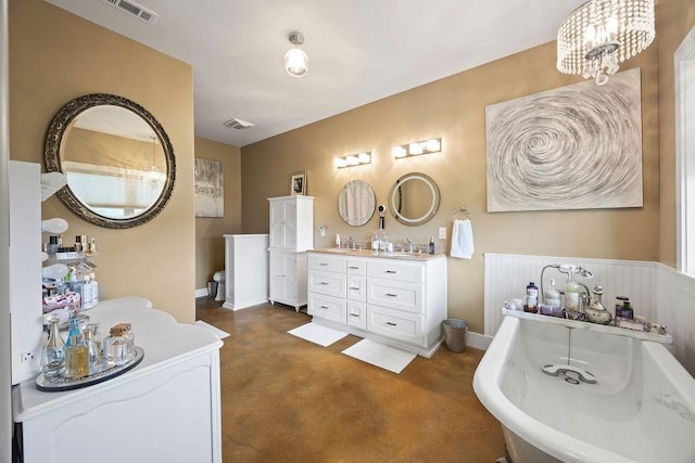 bathroom with visible vents, finished concrete flooring, a freestanding bath, a sink, and a chandelier