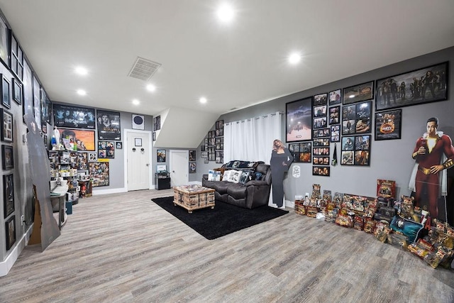living area with recessed lighting, visible vents, and wood finished floors