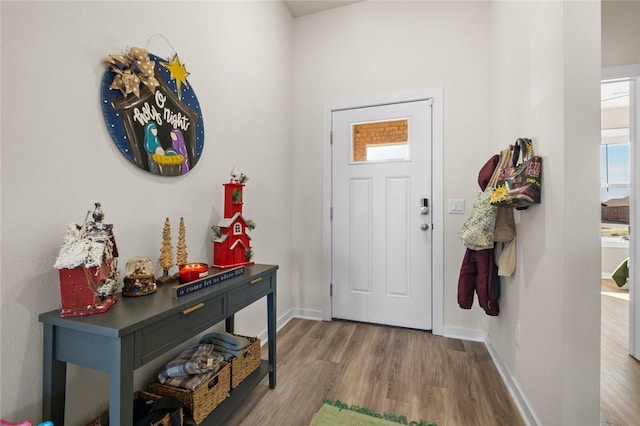 foyer featuring baseboards and wood finished floors