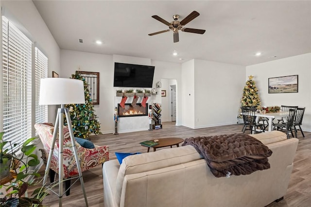 living room featuring ceiling fan, recessed lighting, baseboards, and wood finished floors