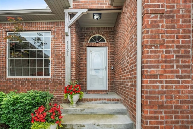 doorway to property with brick siding