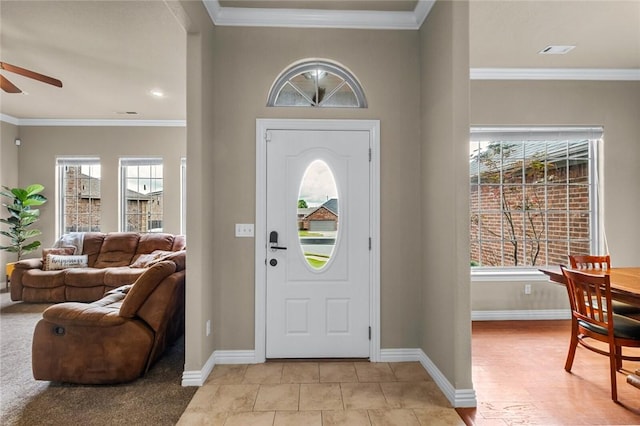 entryway with a ceiling fan, baseboards, ornamental molding, and light tile patterned floors
