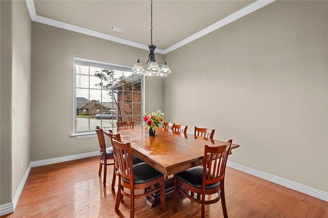 dining space with a chandelier, plenty of natural light, ornamental molding, and baseboards