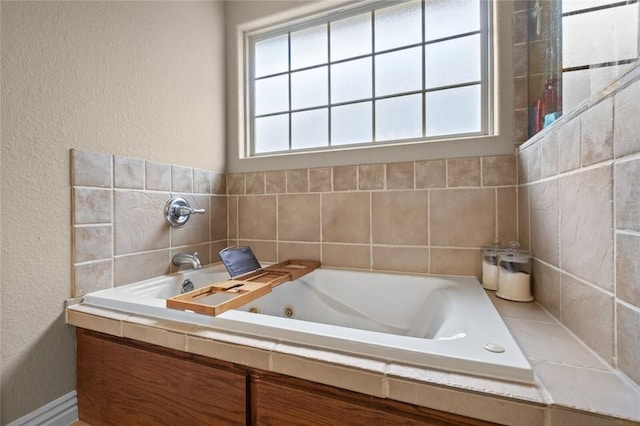 full bath featuring a textured wall and a whirlpool tub